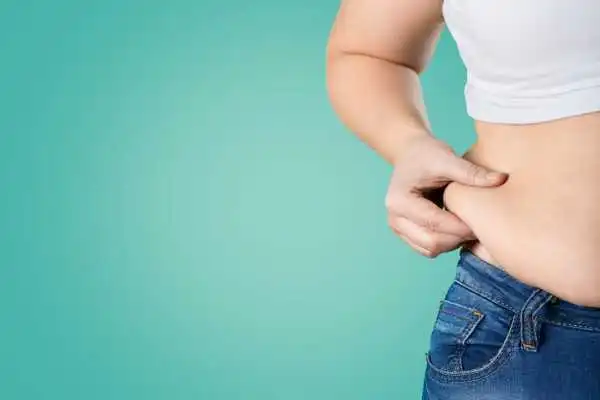 Image of woman pinching her love handles to show weight gain Highworth